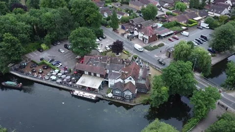 Aerial video of drone flying down and camera paning up showing riverside pub and Stock Footage 201770620