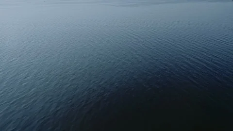 Aerial video of endless, blue, empty sea or ocean water surface at sunset. Stock Footage 122512300