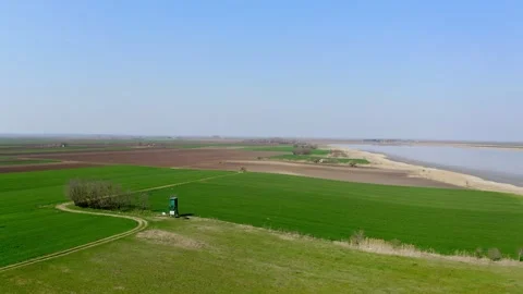Aerial video of green fields surrounding a lake in nature reserve Slano Kopovo Stock Footage 270501888