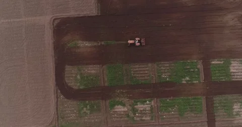Aerial video made while flying above a farm and a tractor on the ground Stock Footage 291677830