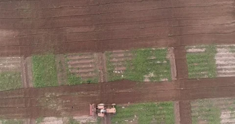 Aerial video made while flying above a farm and a tractor on the ground Stock Footage 291677873