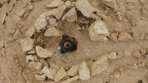 Aerial video of a man sitting between stones in a circular shape in the Judean Stock Footage 289028843