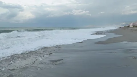 Aerial Video: Rolling storm waves leave intricate foam patterns on the scenic Stock Footage 300900048