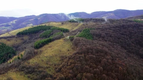 Aerial video of smoke coming out of woods and small house on mountain Stock Footage 269541253