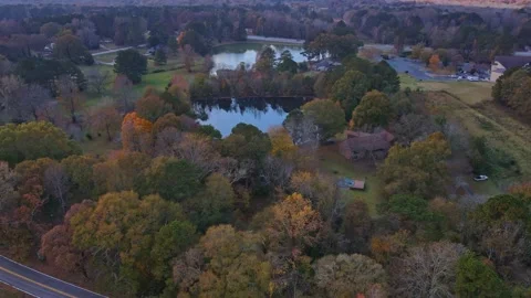 Aerial up to view of 2 gorgeous fall lakes in country settings over a road Stock Footage 170461701