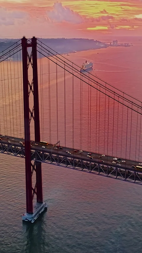 Aerial view of 25 de Abril bridge over the Tagus River at sunset in Lisbon Stock Footage 318595405