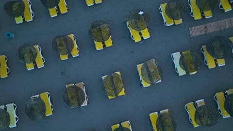 Aerial View 4K: Beachfront Elegance - Stylish Loungers by the Sea Stock Footage 293449843