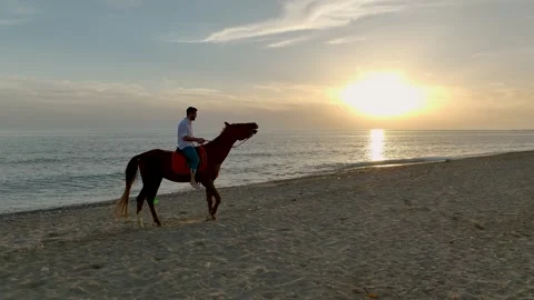 Aerial View 4K: Equestrian Sunset - Horseback Ride Along the Mediterranean Stock Footage 293583909