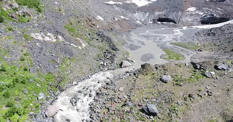 Aerial View. 4K flying over the mountain stream to the glacier Stock Footage 73335840