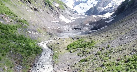 Aerial View. 4K flying over the mountain stream to the glacier Stock Footage 73935792