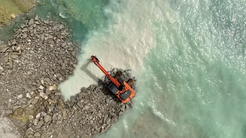 Aerial View 4K: Man vs. Nature - Crafting Comfort from Rocky Coasts Stock Footage 293460603