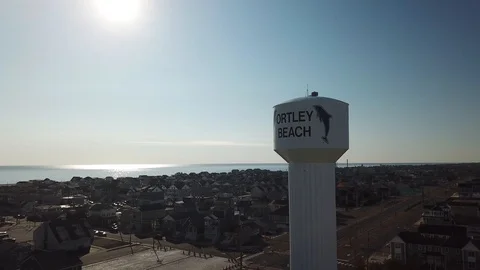Aerial View 4K - Ortley Beach Water Tower and Sparkling Ocean - Backwards Stock Footage 124448722
