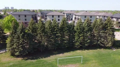 Aerial View 4K tilt down over an empty soccer field, tilt to suburbs Stock Footage 154459703