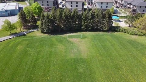 Aerial View 4K  zoom into an empty soccer field, tilt to suburbs Stock Footage 154459760