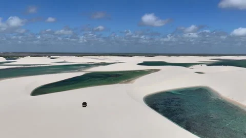 Aerial View of a 4WD Between White Dunes and Turquoise Lagoons Video stock 342444164