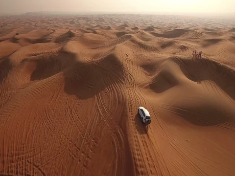 Aerial view of 4x4 off vehicle taking tourists on desert dune bashing safari Stock Footage 71506600