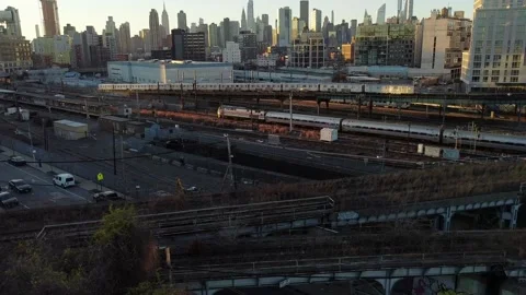 Aerial View, 7 train, Amtrak &amp; LIRR pulling into Hunters Point with NYC Skyline Stock Footage 144841755
