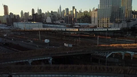 Aerial view of The 7 train and Amtrak at Hunters Point with New York Skyline Stock Footage 144841250
