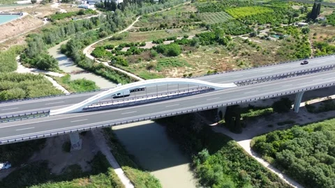 Aerial view of A7 highway bridge crossing green landscape in Spain Stock-Footage 334811816