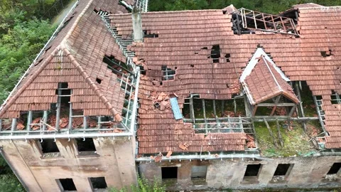 Aerial view of abandoned building with collapsed roof surrounded by forest Video stock 327925571