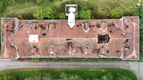 Aerial view of abandoned building with collapsed roof surrounded by forest Stock-Footage 327927206