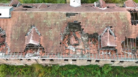 Aerial view of abandoned building with collapsed roof surrounded by forest Stock Footage 327927208