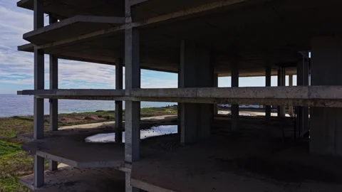 Aerial view of abandoned concrete structure by the ocean shore Stock Footage 325086788