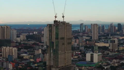 Aerial view of an abandoned skyscraper construction site built in Manila at dusk Stock Footage 276519611