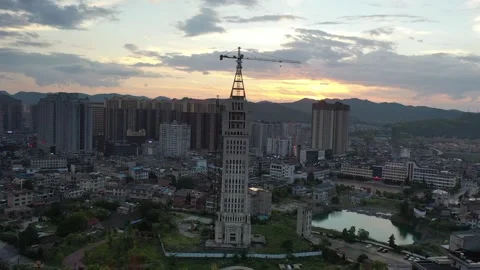 Aerial view of abandoned skyscraper with crane in Dushan, China at sunset 스톡 동영상 345155985