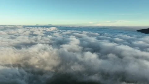 Aerial View Above Clouds and Mountains at Sunrise Stock Footage 244725547