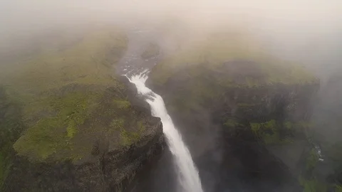 Aerial view above the clouds of a breathtaking waterfall, Iceland. Stock Footage 102142220
