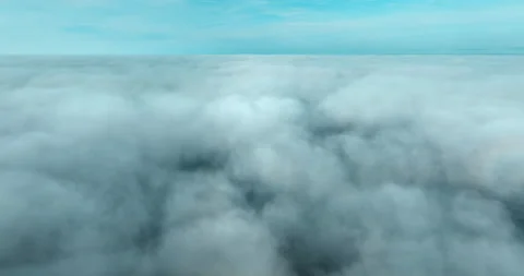 Aerial view above the clouds during sunrise. Foggy morning. Drone flies over Stock Footage 237693944