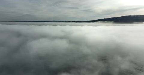 Aerial view above the clouds during sunrise. Foggy morning. Drone flies over Stock Footage 237750586