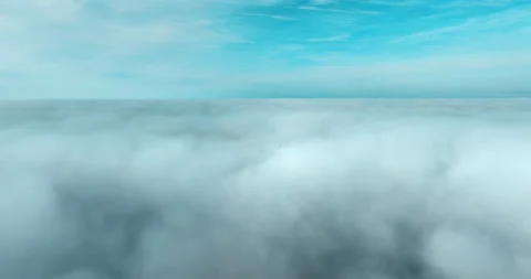 Aerial view above the clouds during sunrise. Foggy morning. Drone flies over Stock Footage 237811019