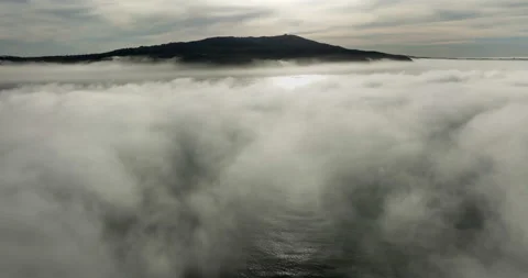 Aerial view above the clouds during sunrise. Foggy morning. Drone flies over Stock Footage 240016180