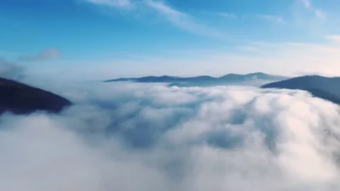 Aerial view above clouds with mountains and hills in the background Stock Footage 234639953