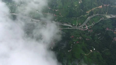Aerial view above clouds revealing village settlements - Green and Forest Hills Vídeo Stock 339371082