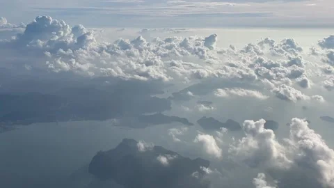 Aerial view from above the clouds showing the tropical landscape and coastline o Stock Footage 346821507