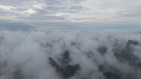 Aerial view above dense cloud layer over distant mountain peak Stock-Footage 310097721