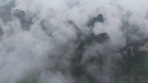 Aerial view above dense cloud layer over distant mountain peak Stock-Footage 310097904