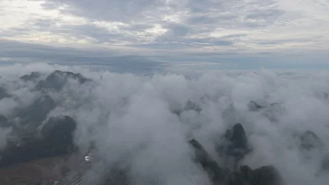 Aerial view above dense cloud layer over distant mountain peak Video stock 310097907
