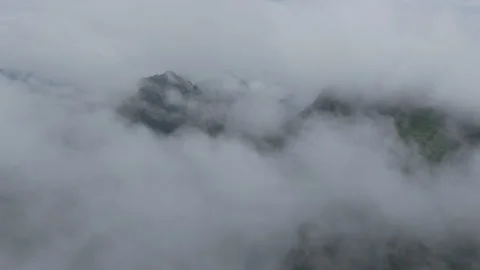 Aerial view above dense cloud layer over distant mountain peak Stock-Footage 310098298