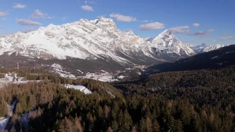 Aerial view above forest with massive Dolomites mountain background in winter Stock Footage 285717087