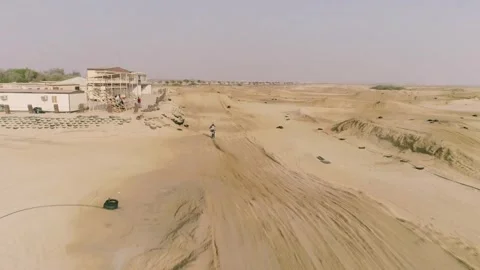 Aerial view above of man practicing motocross at desert landscape. Stock Footage 345224337