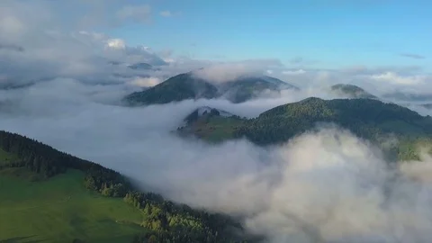 Aerial view above mist clouds in magic country landscape at morning sunrise Stock Footage 81054552
