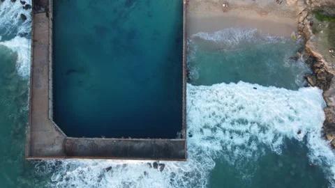 Aerial view above a small sandy beach next to a swimming pool. Stock Footage 290440794