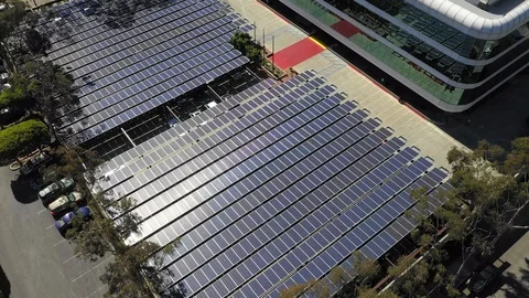 Aerial view above Solar panel array on business park. Descending to tilt Stock Footage 117930524