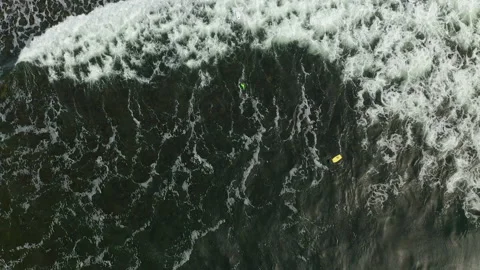 Aerial view from above of surfers practicing in the ocean waves Stock Footage 153276442
