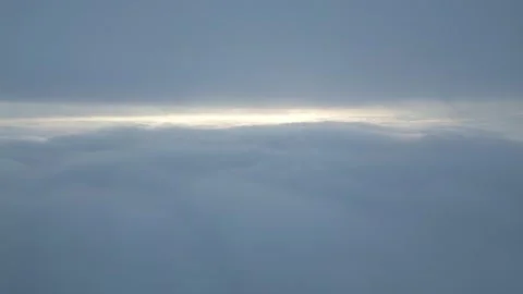 Aerial View Above Thick Clouds with Sun Peeking Through Horizon Stock-Footage 332712614