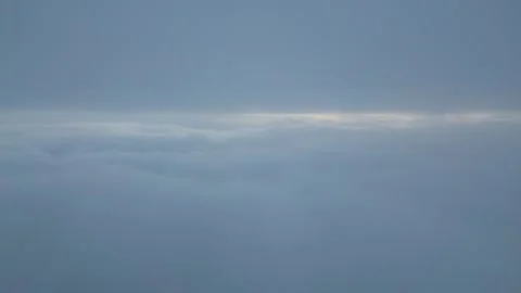 Aerial View Above Thick Clouds with Sun Peeking Through Horizon Stock-Footage 332713554